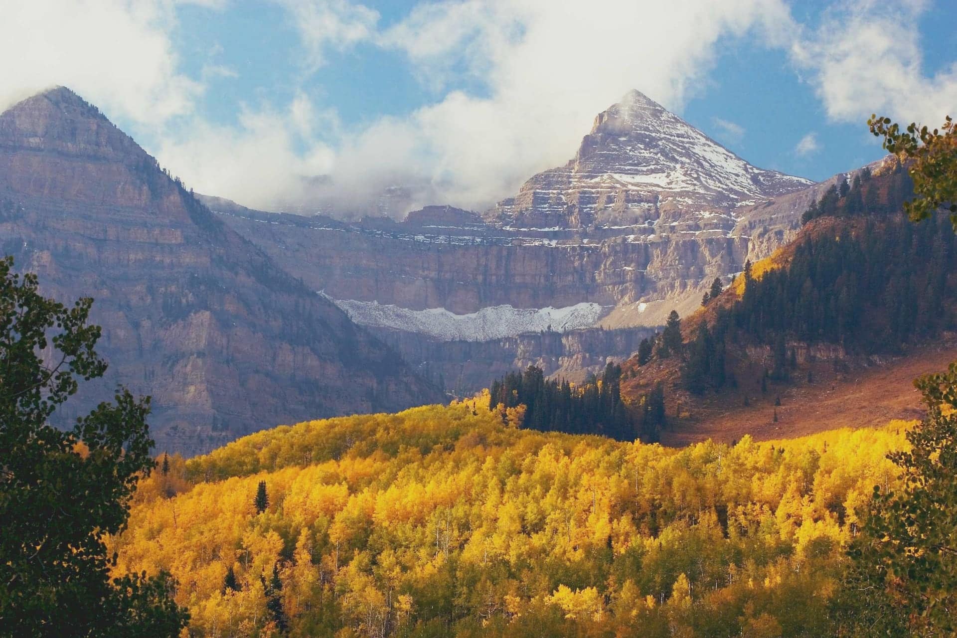An aerial view of the snow-dusted Wasatch Front and golden autumn aspens above the Salt Lake Valley